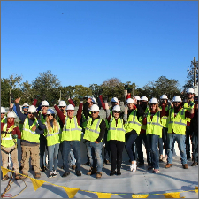 Group photo of volunteers of a non-profit organization wearing hardhats and high visibility vests