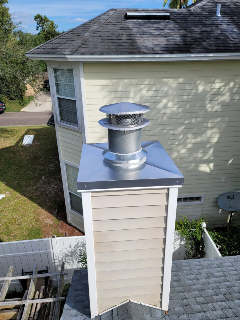 wood sided chimney with metal chimney crown and cap