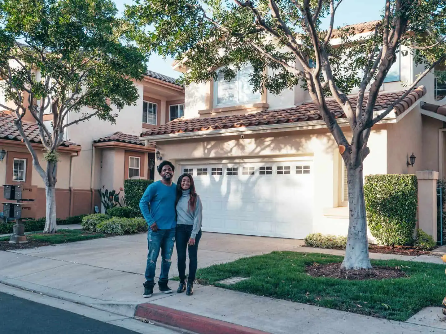 Young couple standing in front of suburban home