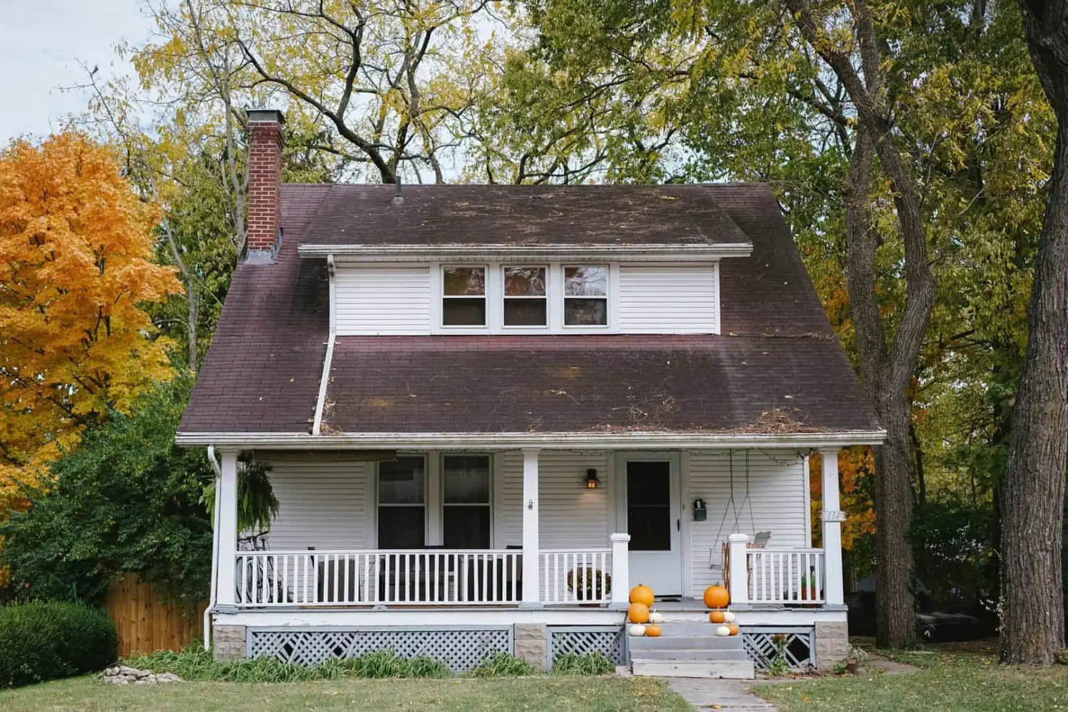 suburban home during fall with pumpkins on porch