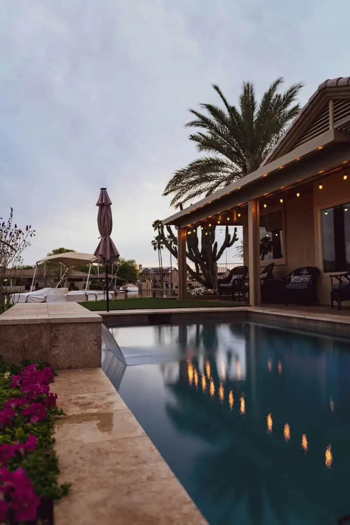 Patio of a home with a pool at dusk